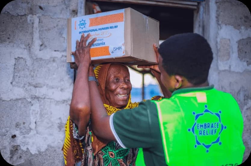 An Embrace Relief volunteer delivering a food package to a woman